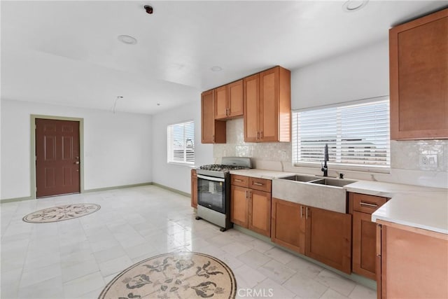 12185 Atsina Rd, Phelan, CA 92371 - kitchen featuring stainless steel gas range, light countertops, a sink, and tasteful backsplash