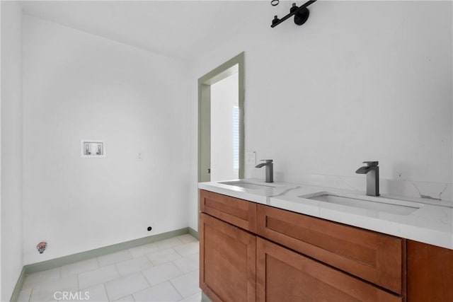 12185 Atsina Rd, Phelan, CA 92371 - washroom with baseboards, a sink, washer hookup, and cabinet space