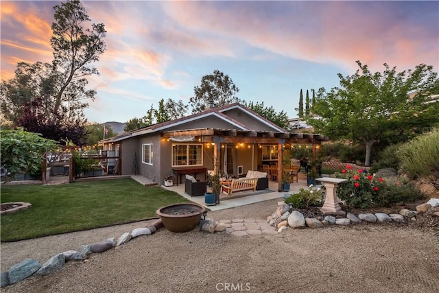 33660 White Feather Rd, Acton, CA 93510 - back of property at dusk featuring an outdoor living space, a patio area, stucco siding, and a lawn