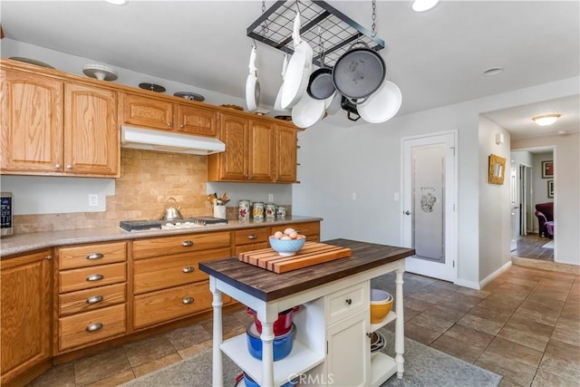 33660 White Feather Rd, Acton, CA 93510 - kitchen with open shelves, under cabinet range hood, gas stovetop, butcher block counters, and decorative backsplash