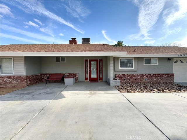 entrance to property featuring brick siding, stucco siding, and a chimney