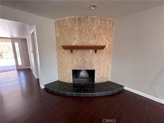 interior space with baseboards, a fireplace, and wood finished floors