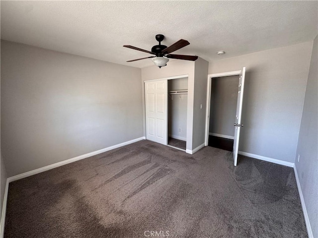 unfurnished bedroom featuring baseboards, a closet, dark carpet, and a textured ceiling