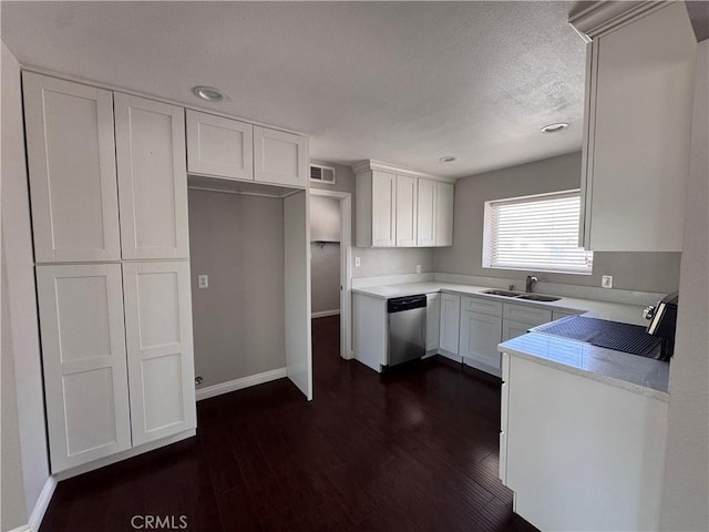 kitchen featuring stainless steel dishwasher, visible vents, white cabinets, a sink, and dark wood finished floors