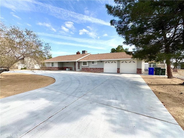 view of front of home with a garage, driveway, and a chimney
