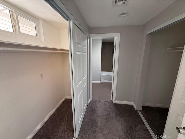 corridor featuring carpet flooring, baseboards, and visible vents