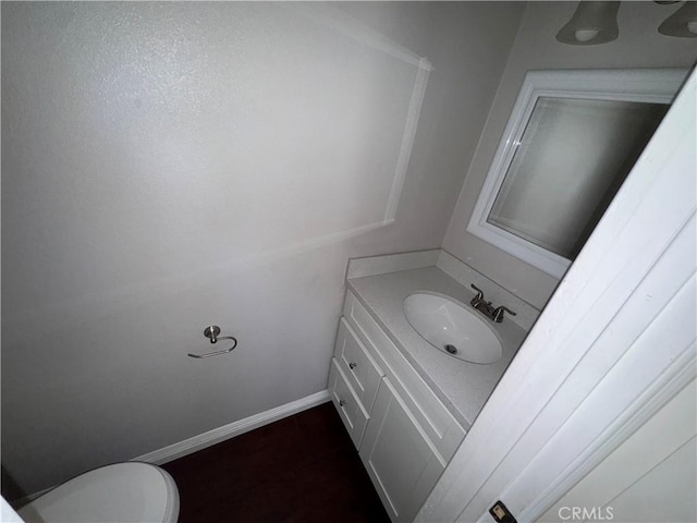 bathroom featuring vanity, baseboards, and toilet