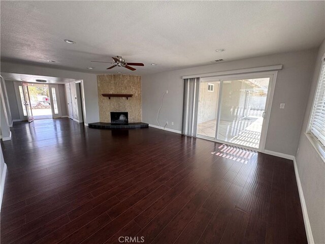 unfurnished living room featuring ceiling fan, a fireplace, a textured ceiling, recessed lighting, and baseboards