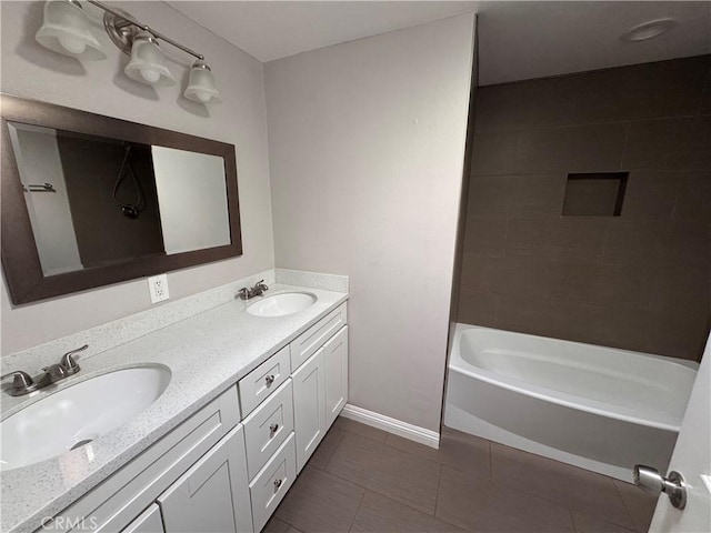 full bathroom with double vanity, a sink, baseboards, and tile patterned floors