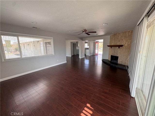 unfurnished living room with a large fireplace, a ceiling fan, baseboards, recessed lighting, and dark wood-style floors
