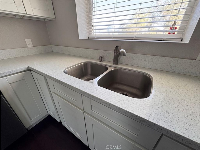 kitchen featuring a sink and white cabinets