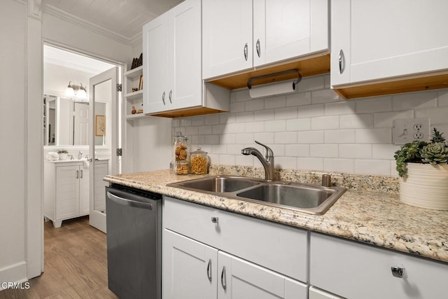 kitchen featuring stainless steel dishwasher, wood finished floors, white cabinetry, a sink, and backsplash