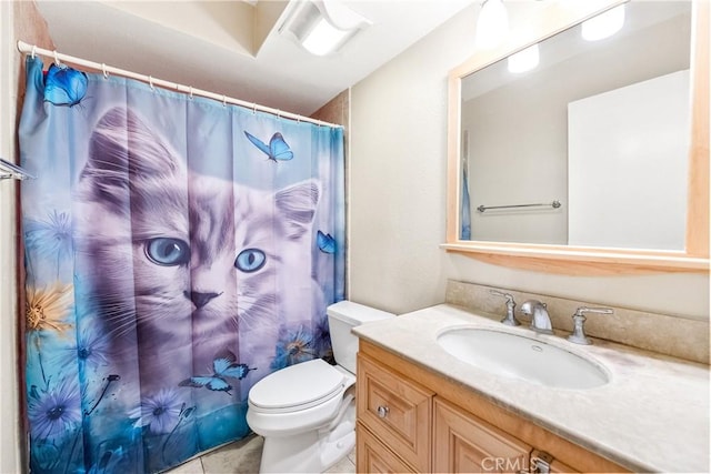 bathroom featuring vanity, tile patterned floors, toilet, and curtained shower