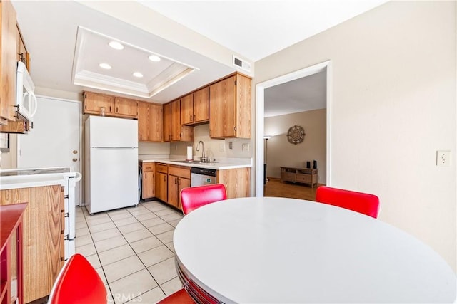 kitchen featuring white appliances, light countertops, recessed lighting, a tray ceiling, and visible vents