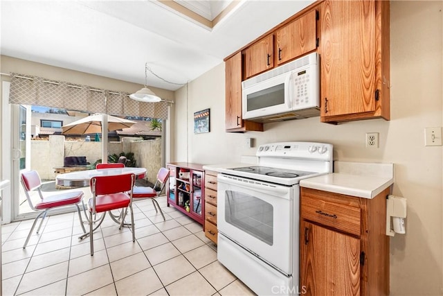 kitchen with brown cabinetry, pendant lighting, white appliances, light countertops, and light tile patterned floors