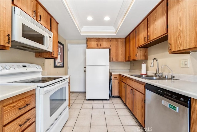 kitchen with ornamental molding, white appliances, brown cabinets, a tray ceiling, and a sink