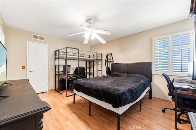 bedroom with a ceiling fan, baseboards, visible vents, and light wood finished floors