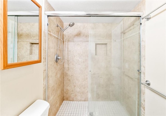 bathroom with a stall shower and toilet