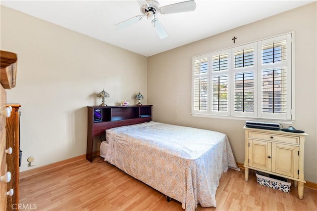 bedroom with a ceiling fan, baseboards, and light wood-type flooring