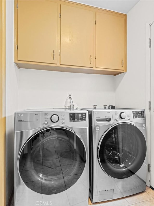 washroom featuring light tile patterned floors, cabinet space, and washer and dryer