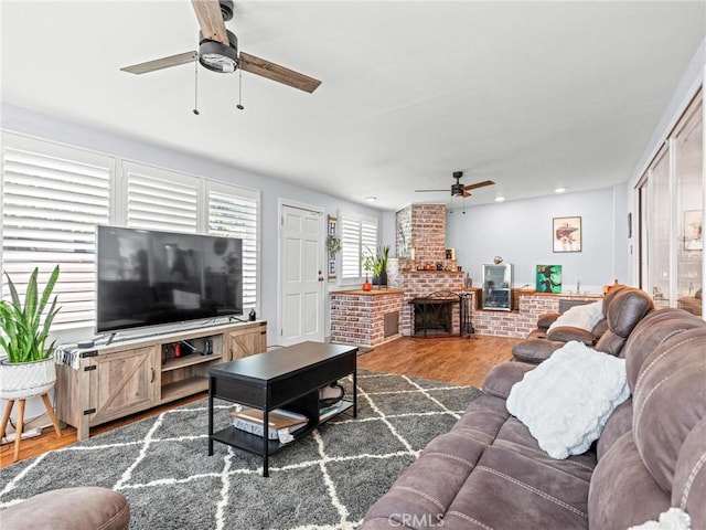 living area with recessed lighting, a brick fireplace, ceiling fan, and wood finished floors