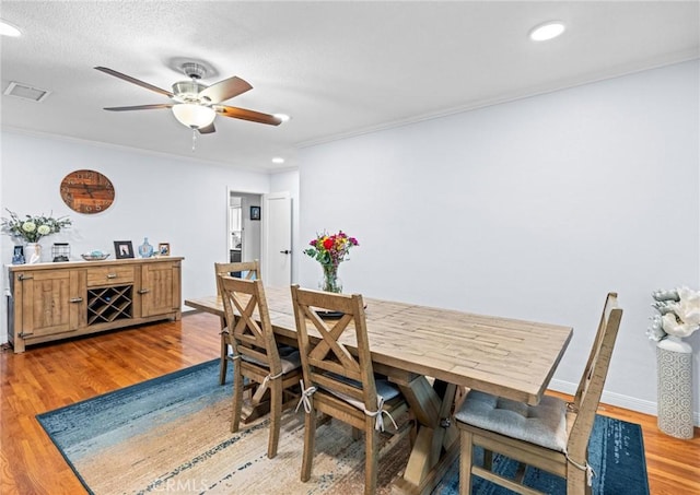 dining space featuring a ceiling fan, visible vents, light wood-style floors, ornamental molding, and recessed lighting