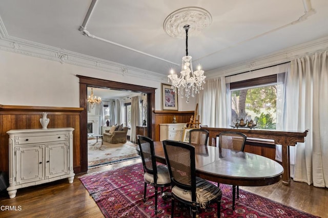 1900 Taft Ave, Los Angeles, CA 90068 - dining room featuring crown molding, wainscoting, an inviting chandelier, and dark wood-style floors