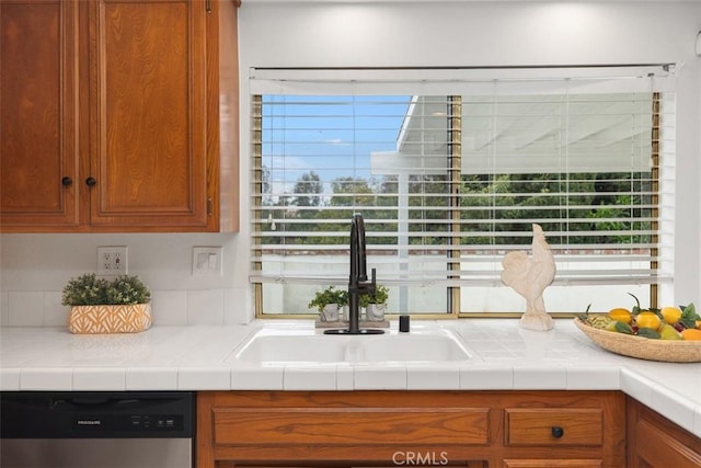 kitchen featuring a sink, stainless steel dishwasher, and brown cabinetry