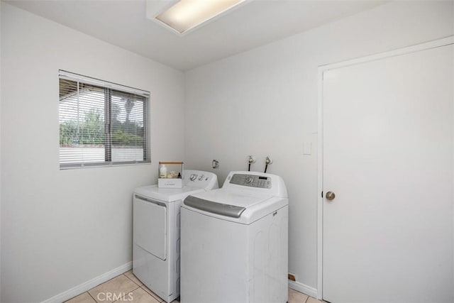 laundry room featuring baseboards, separate washer and dryer, laundry area, and light tile patterned floors
