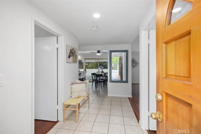 hallway featuring baseboards and light tile patterned floors