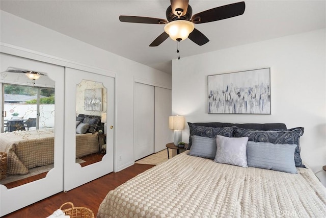 bedroom featuring ceiling fan, multiple closets, and wood finished floors