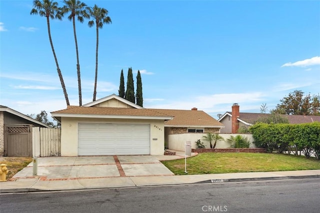 ranch-style home featuring concrete driveway, fence, a front yard, and stucco siding