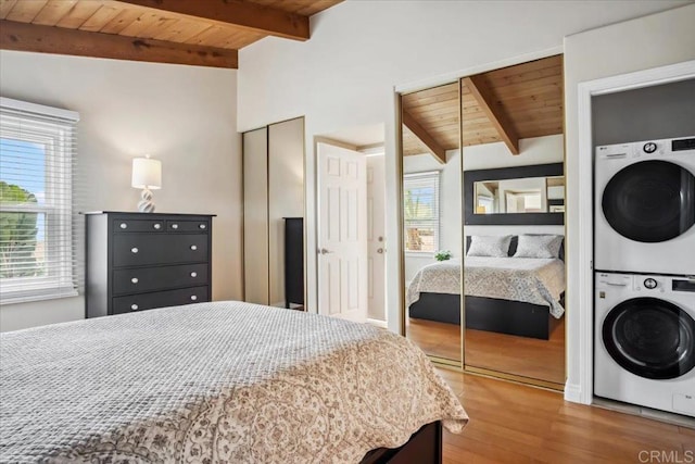 bedroom with stacked washer and dryer, multiple windows, two closets, and wooden ceiling