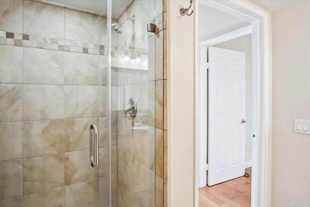 full bath with a shower stall and wood finished floors
