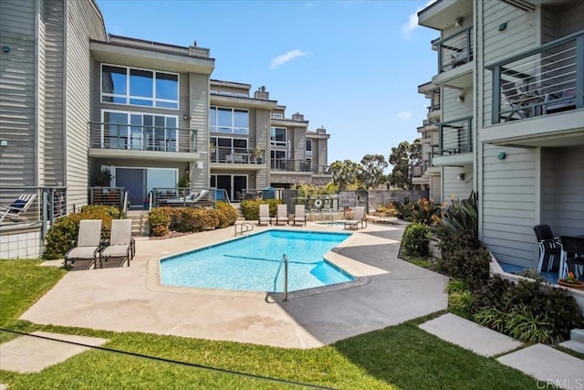 pool with a patio area and fence