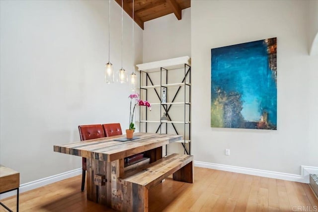 dining room featuring wood-type flooring, lofted ceiling with beams, baseboards, and wood ceiling