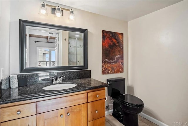 bathroom with vanity, baseboards, tile patterned floors, and toilet