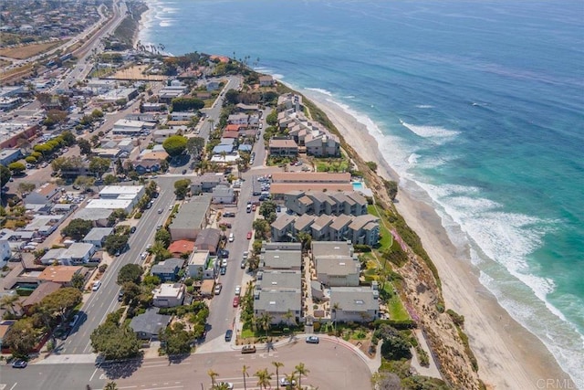 drone / aerial view featuring a water view, a view of the beach, and a residential view