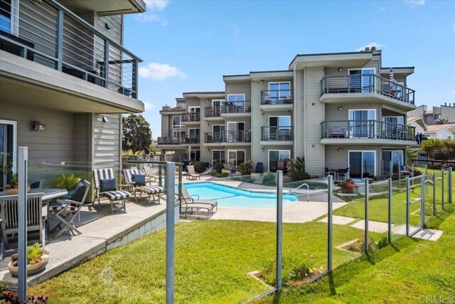 view of swimming pool featuring a fenced in pool, fence, a yard, and a patio