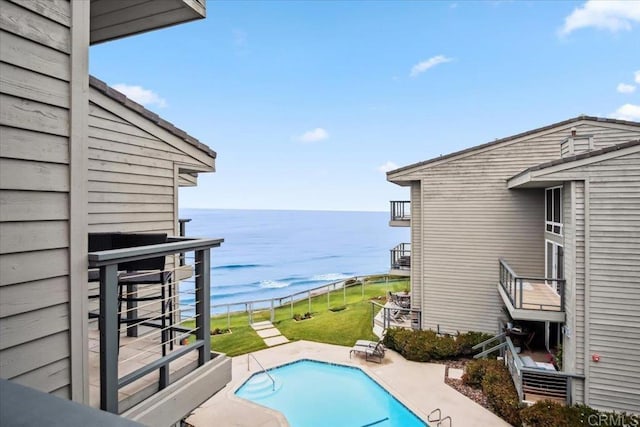 pool featuring a water view and a patio area
