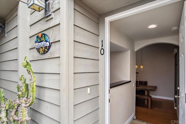interior details featuring arched walkways, baseboards, and recessed lighting