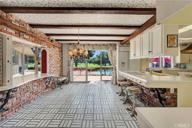 4300 Parkview Dr, Lakewood, CA 90712 - kitchen with light countertops, brick patterned floor, beam ceiling, and a notable chandelier