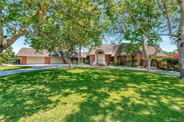 4300 Parkview Dr, Lakewood, CA 90712 - view of front of house with brick siding, a front lawn, mansard roof, and driveway