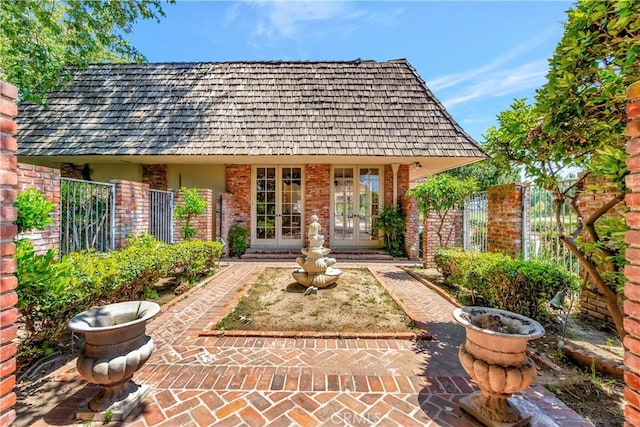4300 Parkview Dr, Lakewood, CA 90712 - rear view of house with brick siding, fence, and french doors