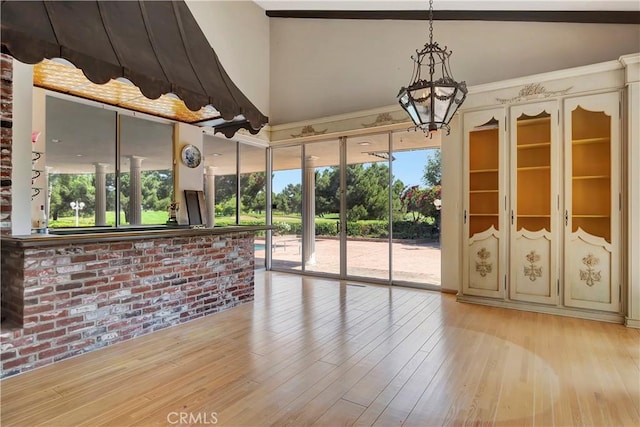 4300 Parkview Dr, Lakewood, CA 90712 - unfurnished living room with an inviting chandelier, wood finished floors, and brick wall