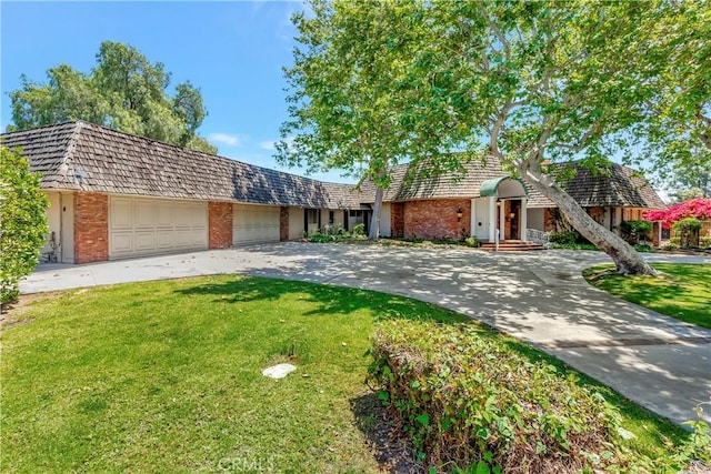 4300 Parkview Dr, Lakewood, CA 90712 - view of front facade with brick siding, a garage, a front yard, mansard roof, and driveway