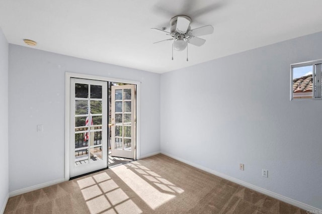 carpeted empty room with ceiling fan and baseboards