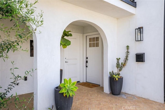 view of exterior entry featuring stucco siding
