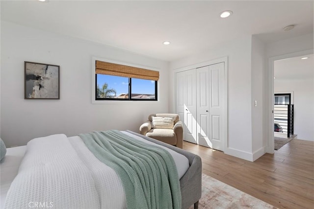 bedroom featuring light wood-style floors, baseboards, a closet, and recessed lighting