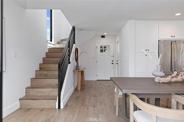 entrance foyer with baseboards, light wood-style flooring, stairs, and recessed lighting